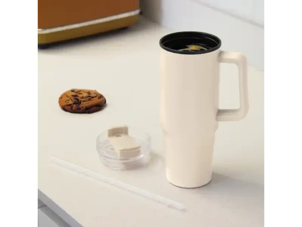 Mug Mega de 880ml con popote y acabado mate en colores beige para transporte y turismo. Sobre una mesa