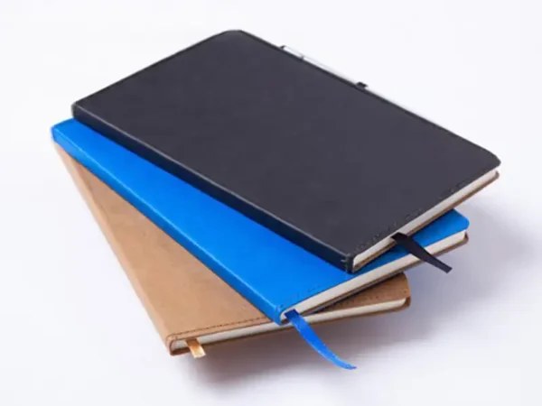 Libreta ecológica Tallin de papel kraft lavable disponible en color café, azul y negro para branding corporativo de Dot Factory. Colores disponibles
