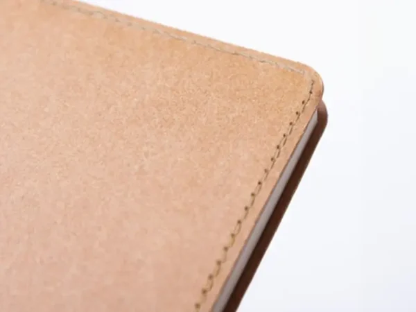 Libreta ecológica Tallin de papel kraft lavable disponible en color café, azul y negro para branding corporativo de Dot Factory. Detalle de la libreta