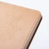 Libreta ecológica Tallin de papel kraft lavable disponible en color café, azul y negro para branding corporativo de Dot Factory. Detalle, contra agua.