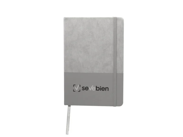 Libreta GAM con tapa bicolor de poliuretano suave al tacto, hojas crema rayadas y cierre de banda elástica.