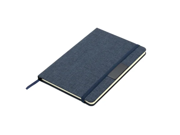 Libreta GRETA sustentable fabricada en RPET con placa metálica para grabado láser y cierre elástico.