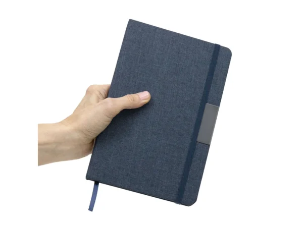 Libreta GRETA sustentable fabricada en RPET con placa metálica para grabado láser y cierre elástico.