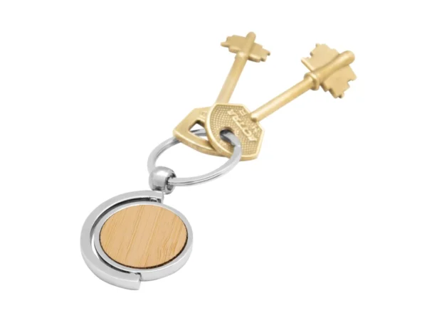 Llavero de bambú SPIN circular con estructura giratoria 360 grados, detalles metálicos y estuche de regalo.