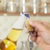 Llavero destapador KIDRINK con estructura metálica brillante, panel de bambú barnizado y estuche de regalo con terciopelo.
