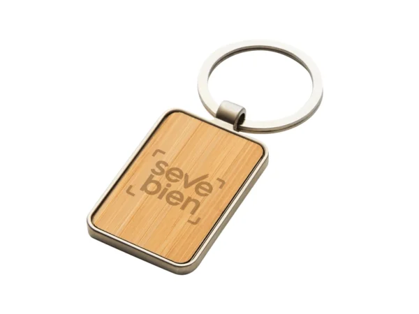 Llavero KIREC rectangular con estructura de metal brillante, panel de bambú barnizado y estuche de regalo con terciopelo negro.