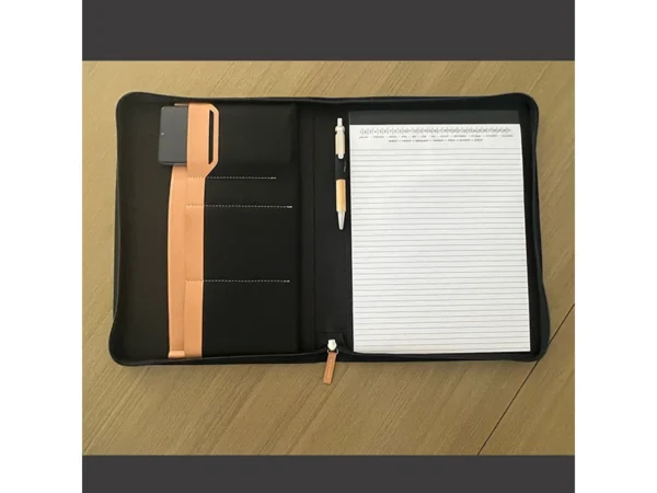 Porta Documentos Yakarta con cierre en zipper, incluye block de notas, portabolígrafos y detalle de lengüeta en curpiel.