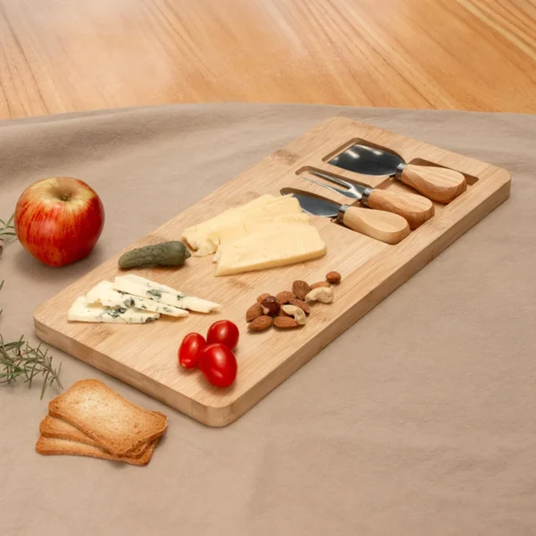Tabla de quesos CHEDDAR. Tabla de bambú con cuchillo, tenedor y espátula de acero inoxidable sobre superficie clara