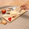 Tabla de quesos CHEDDAR. Tabla de bambú con cuchillo, tenedor y espátula de acero inoxidable sobre superficie clara