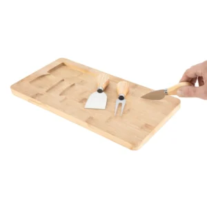 Tabla de quesos CHEDDAR. Tabla de bambú con cuchillo, tenedor y espátula de acero inoxidable sobre superficie clara